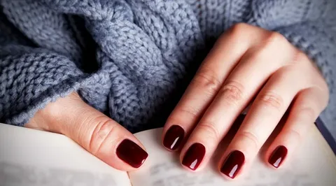 deep red nails with a cozy sweater